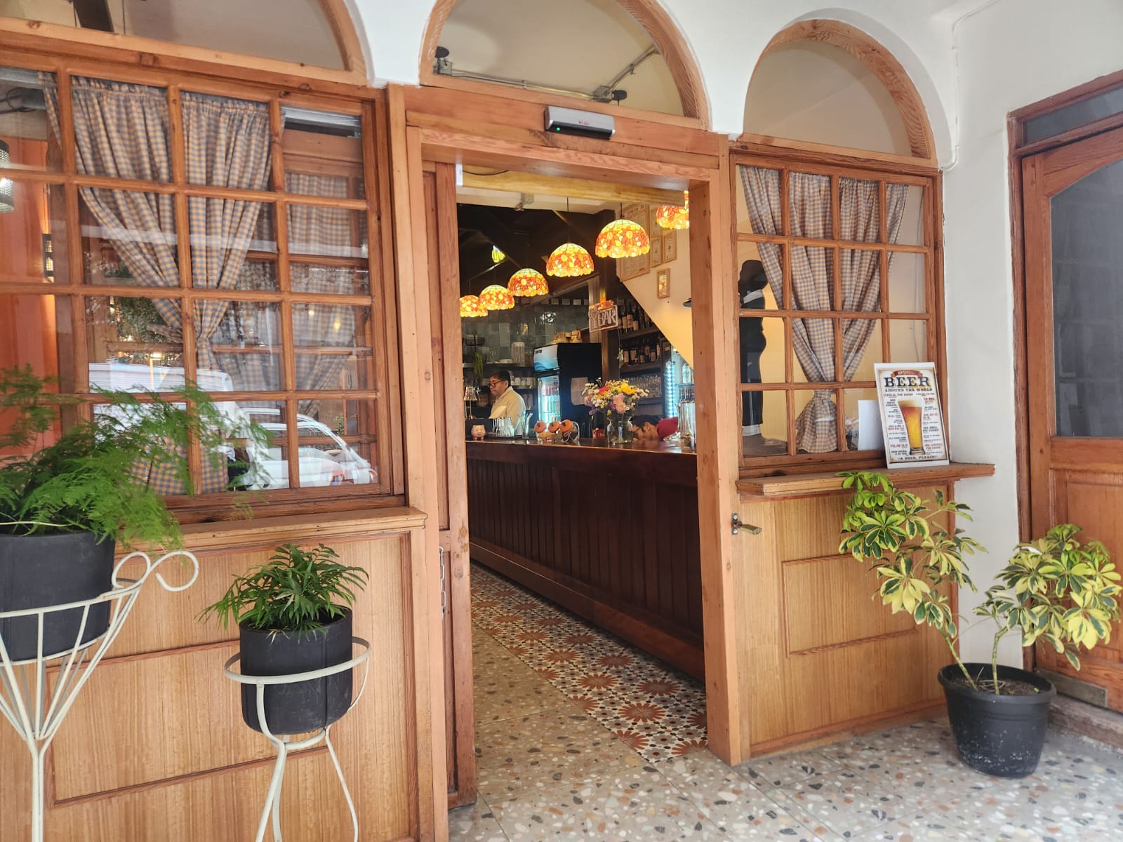 Entrada de Salónica, puertas de madera y barra al fondo
